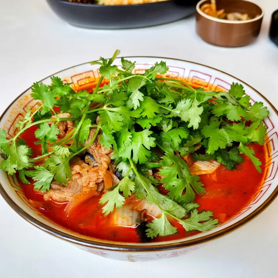 A bowl of mala cilantro jjamppong topped with cilantro