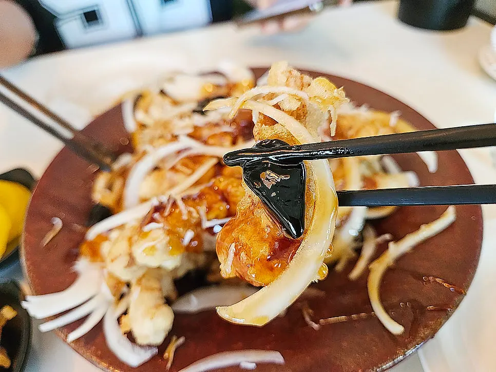 Raw onion strips served alongside the sweet and sour pork