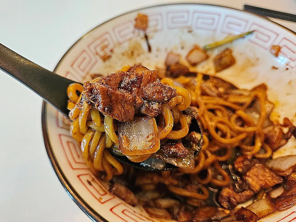 Chewy jjajang noodles being lifted