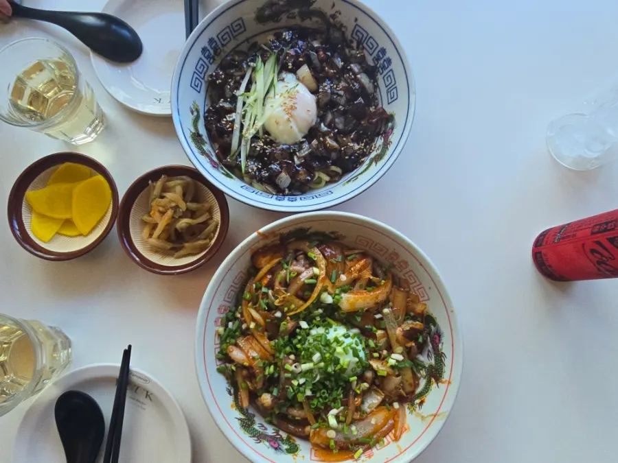 Table spread with poached-egg octopus rice bowl and poached-egg pork jjajang