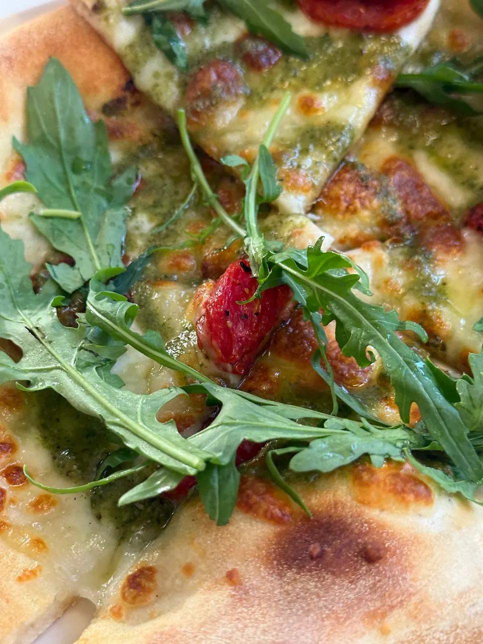 Basil margherita pizza topped with roasted tomato