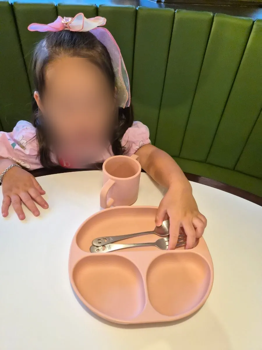 Pink kids' tableware set on the table