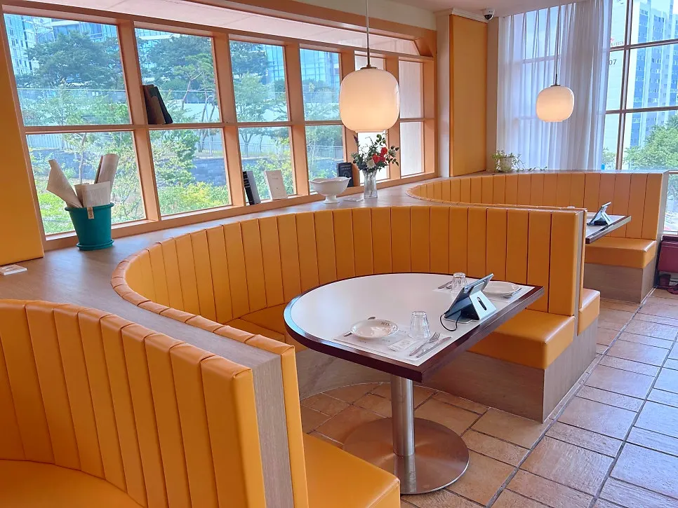Wood-tone seating with large windows and the half-moon table