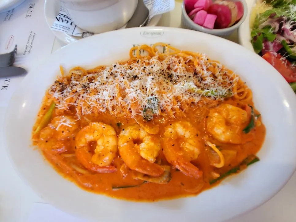 Table setting with shrimp rosé pasta and basil margherita pizza