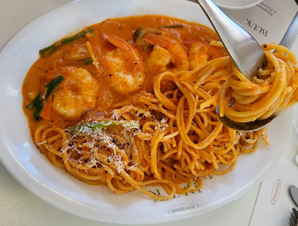 Pasta noodles and shrimp coated in rosé sauce