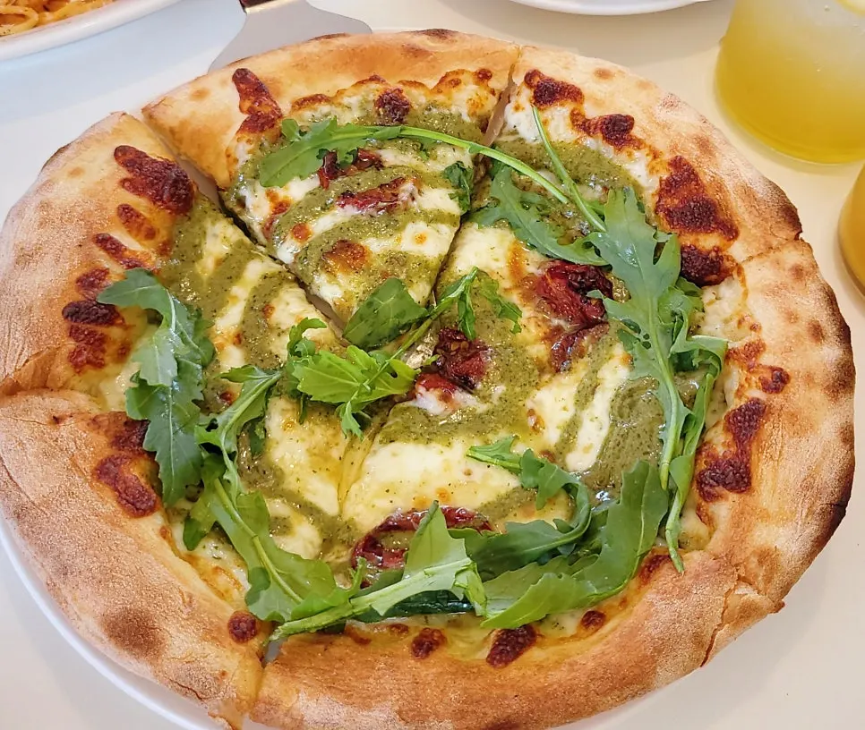 Basil margherita pizza topped with arugula