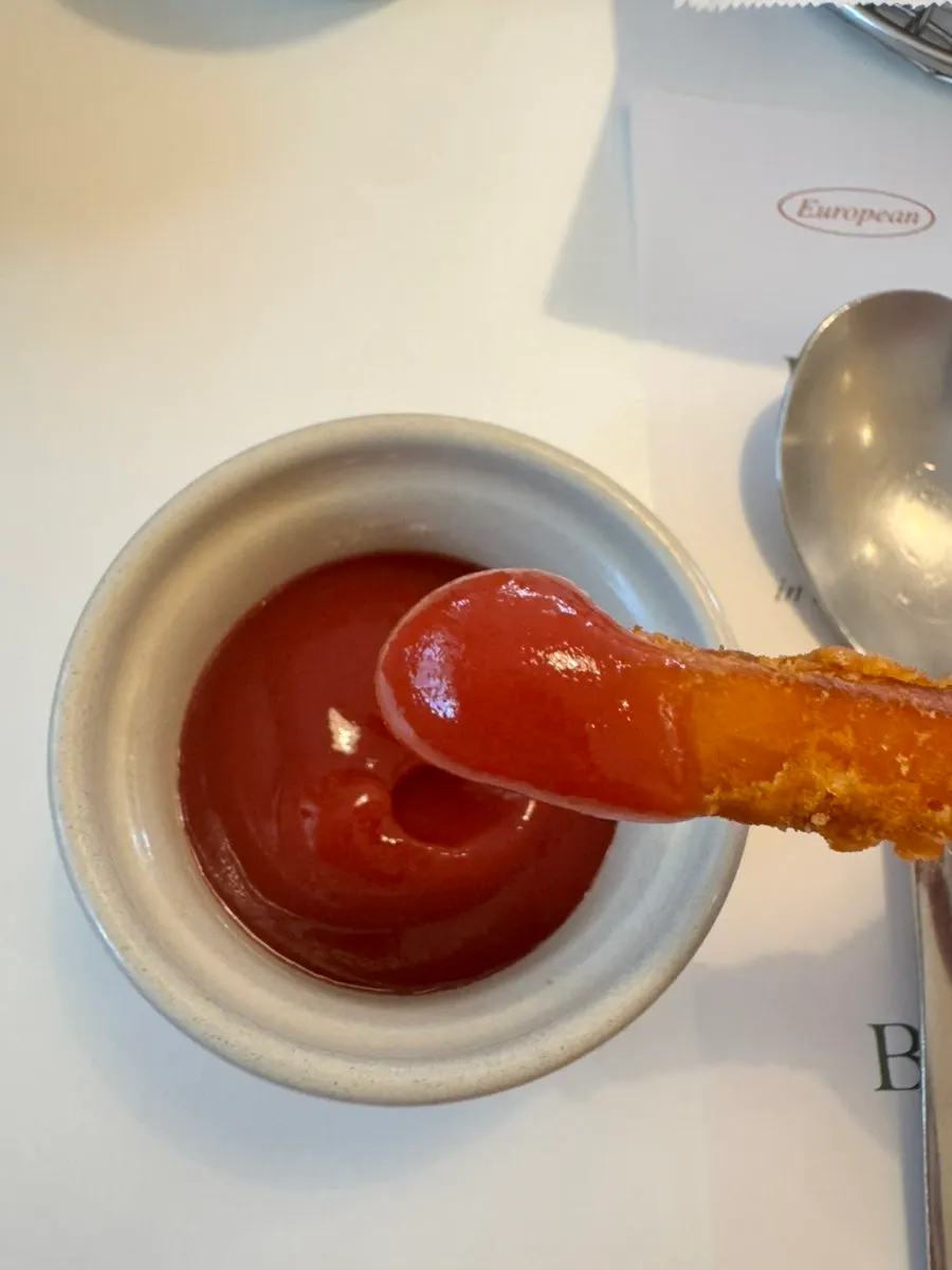 Sweet potato fries dipped in ketchup