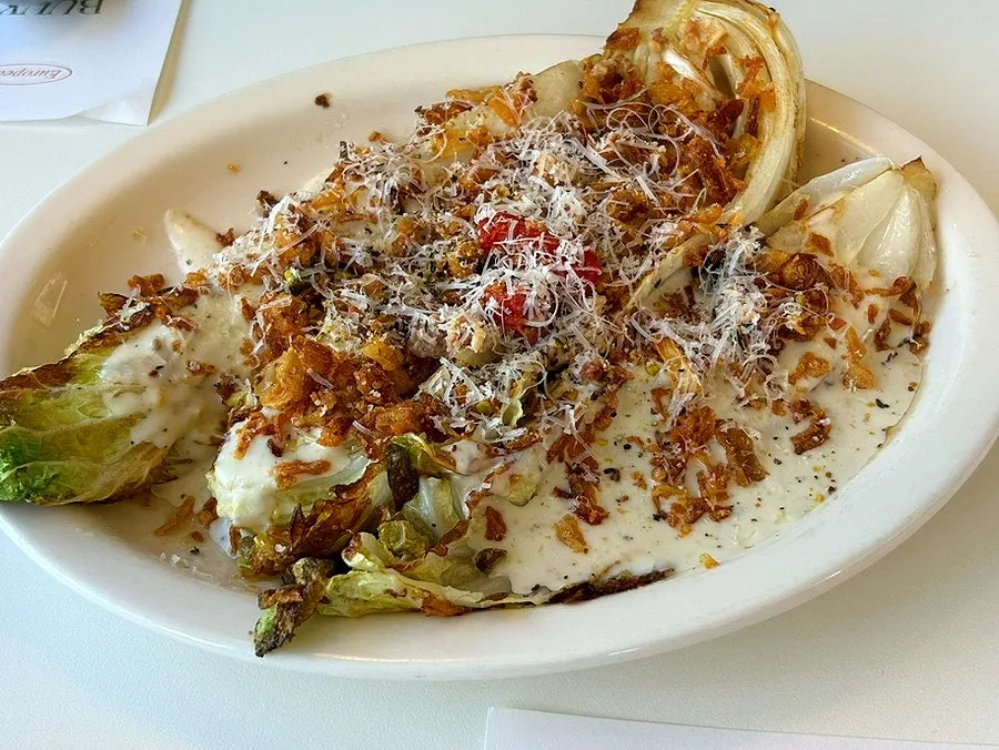 A plate of grilled napa cabbage caesar salad