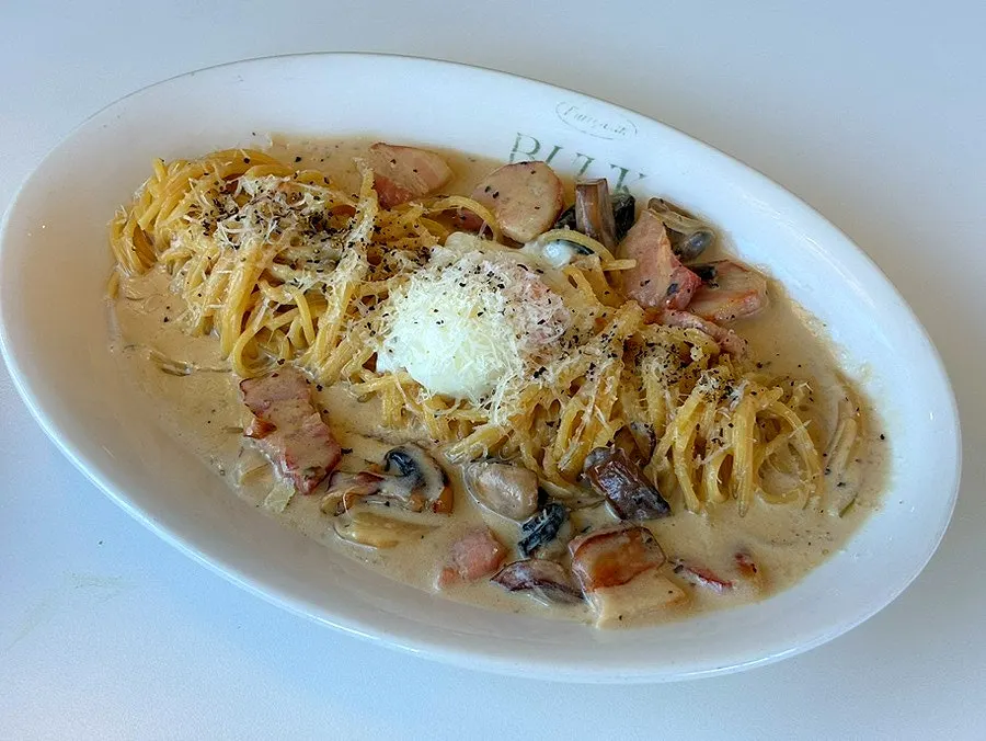 Carbonara pasta topped with a poached egg