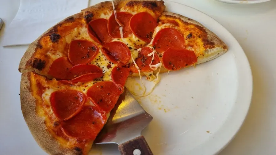 Cross-section of pepperoni pizza with stretchy melted cheese