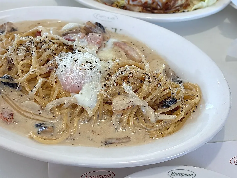 Carbonara pasta topped with a poached egg