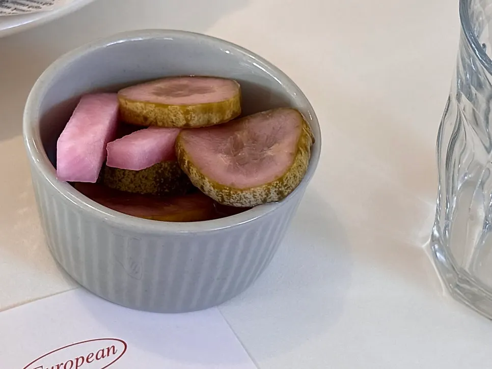 Crunchy pickles served alongside the pasta