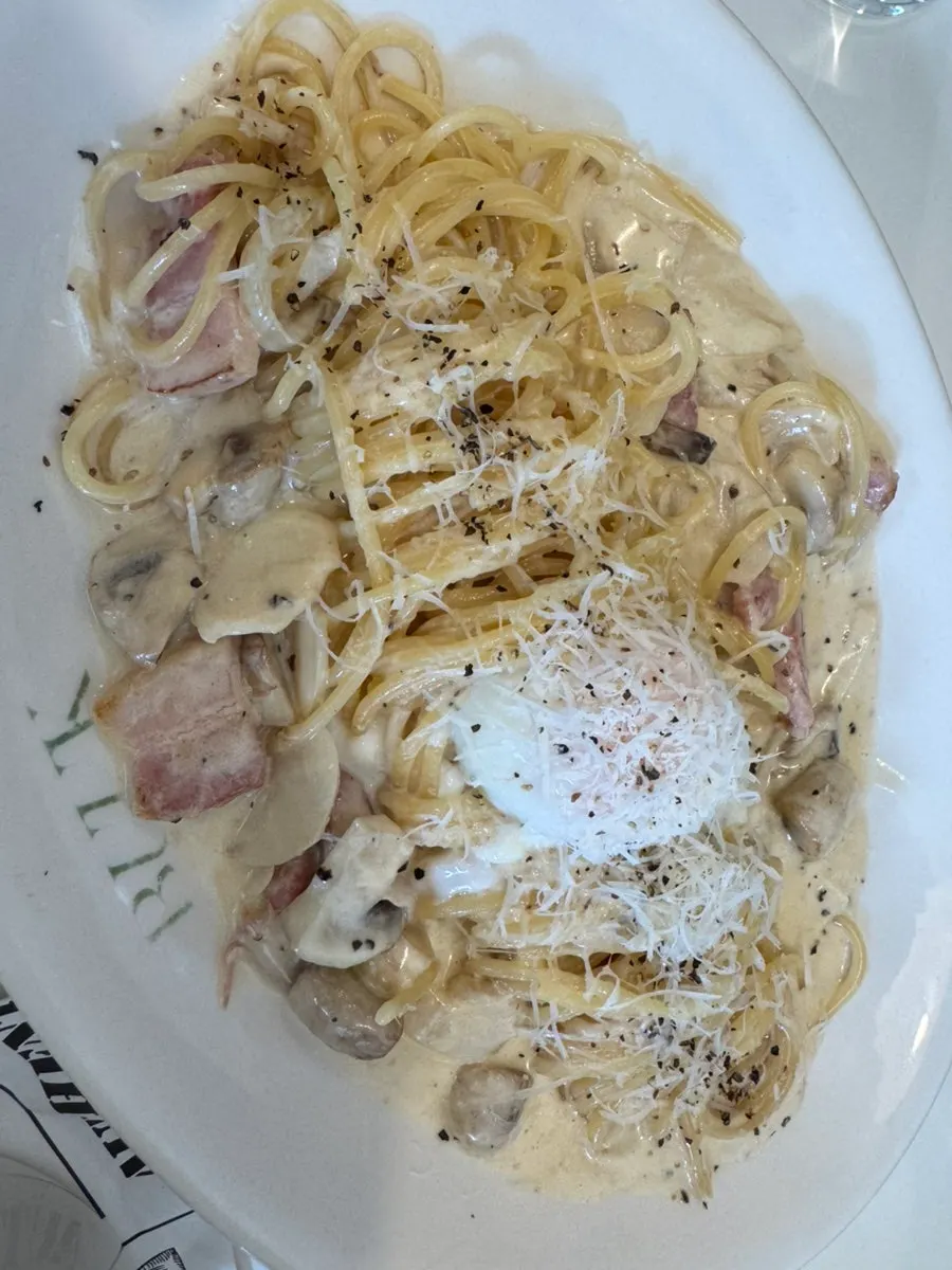 Carbonara pasta topped with a poached egg