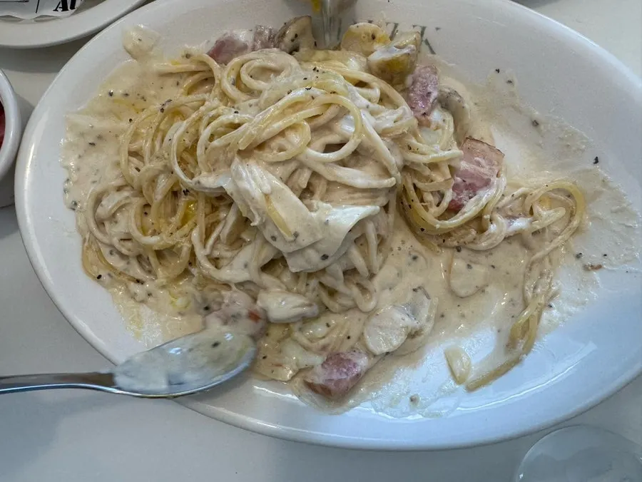 Close-up of creamy carbonara sauce coating the noodles