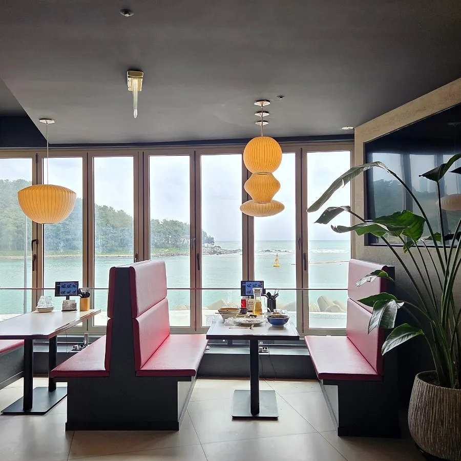 First view of the restaurant with Dongbaekseom and the Haeundae sea through floor-to-ceiling windows