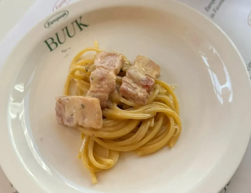 Carbonara noodles lifted with a fork