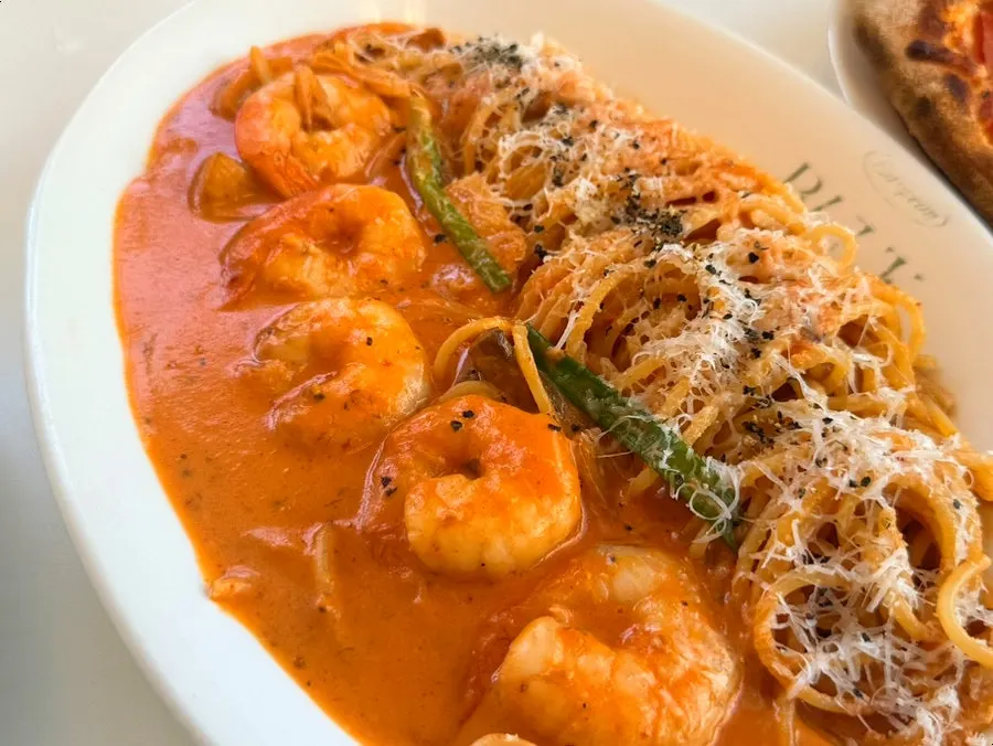 Close-up of plump shrimp piled on the rosé pasta