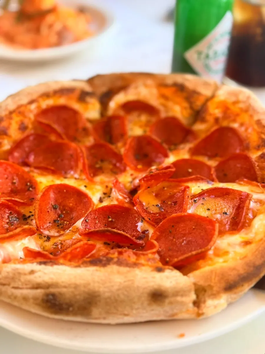 A slice of pepperoni pizza lifted up