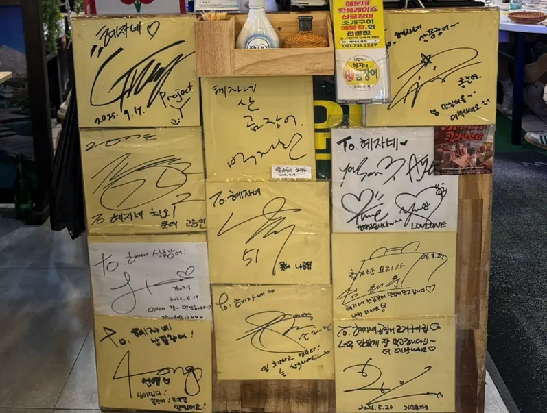 계산대 근처에 걸린 연예인 사인들