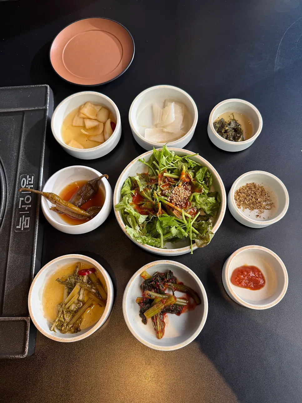 Side dish spread with pickles and wrap greens