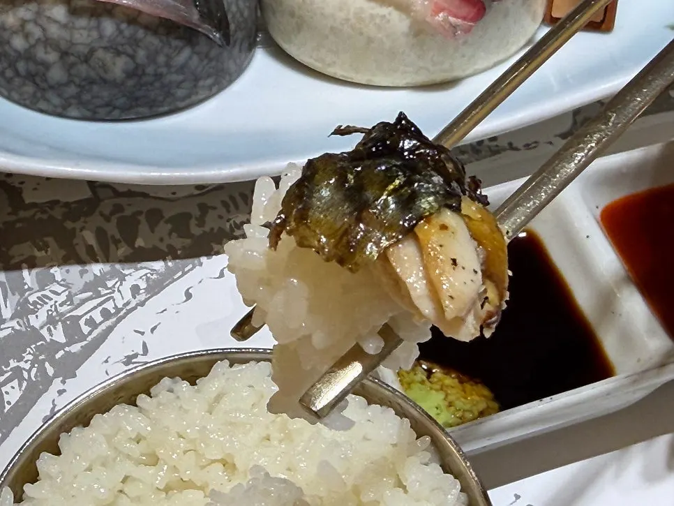 A piece of grilled mackerel served over rice