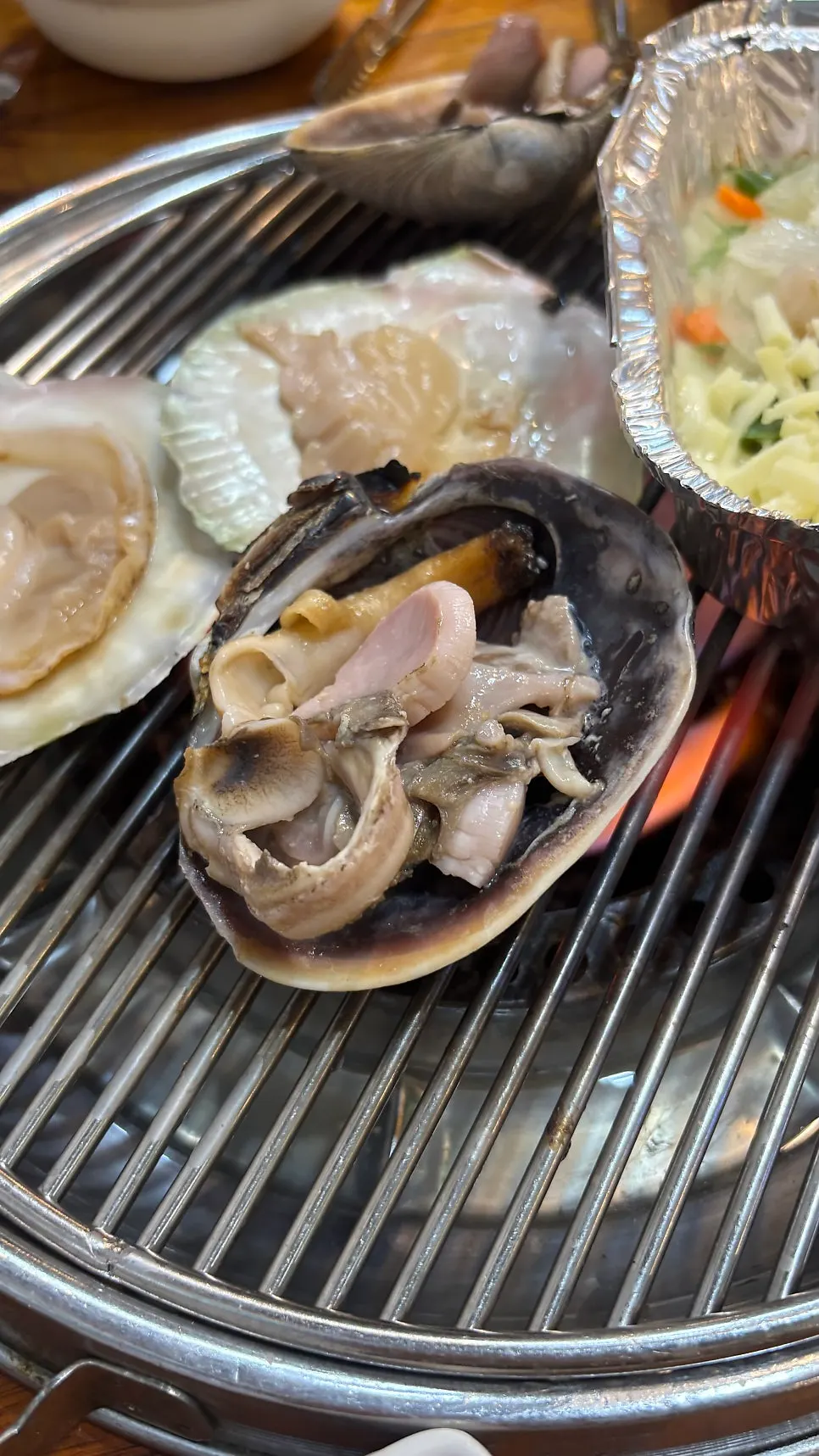 치즈를 올려 익힌 가리비 한 점