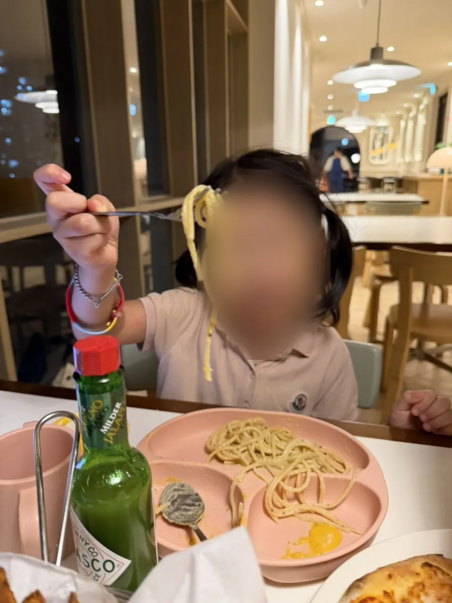 子供のトレーに取り分けたクリームパスタの写真