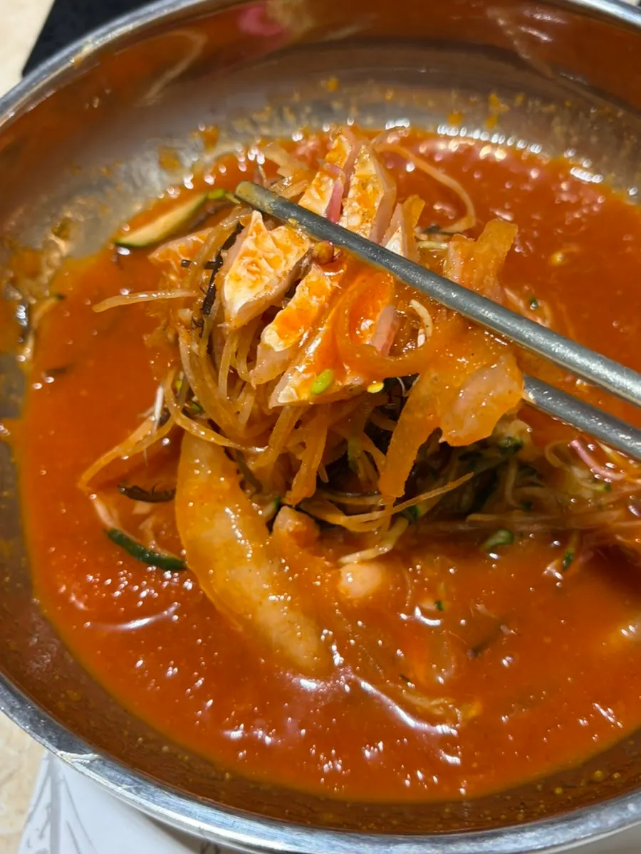 Mulhoe being mixed with vegetables and raw fish