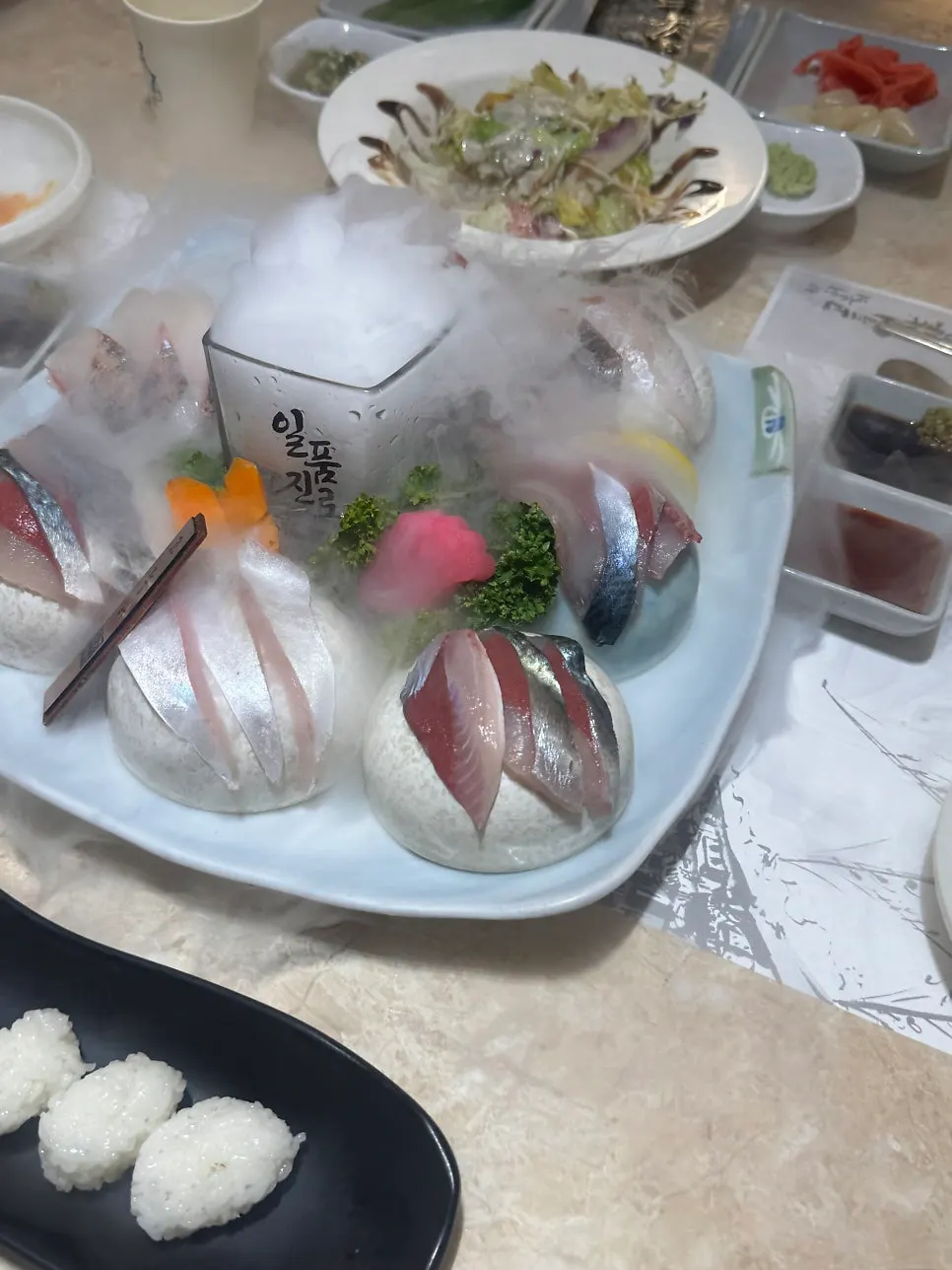 Mackerel and horse mackerel sashimi setting amid smoke