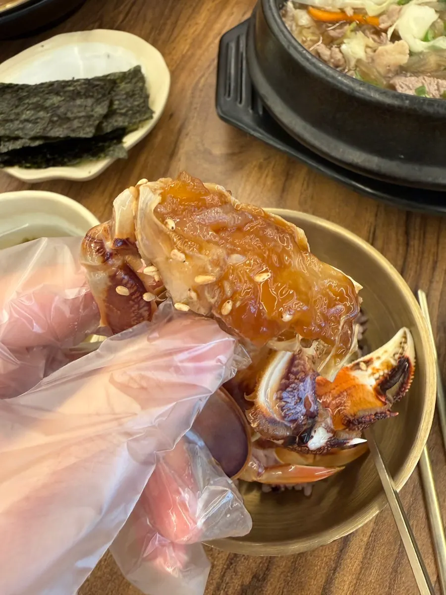 Un bocado de gejang acompañado de arroz en olla