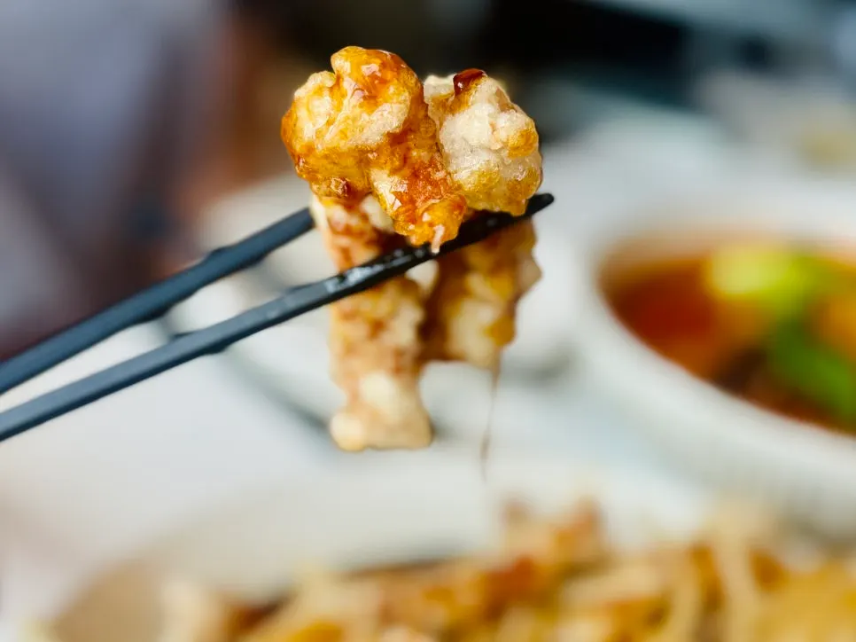 A crispy piece of black-vinegar pork tenderloin tangsuyuk