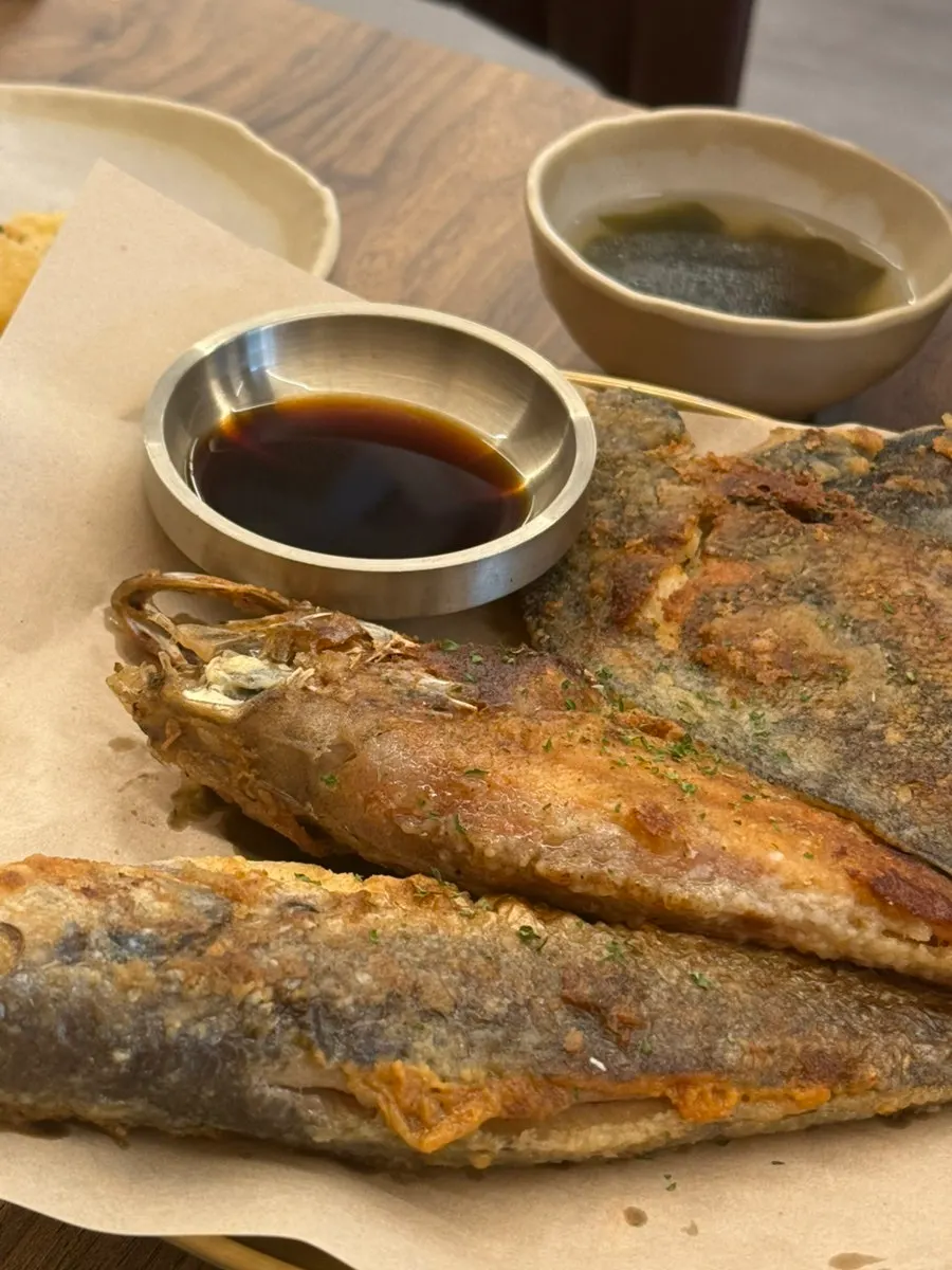 Three golden-grilled fish served at the table