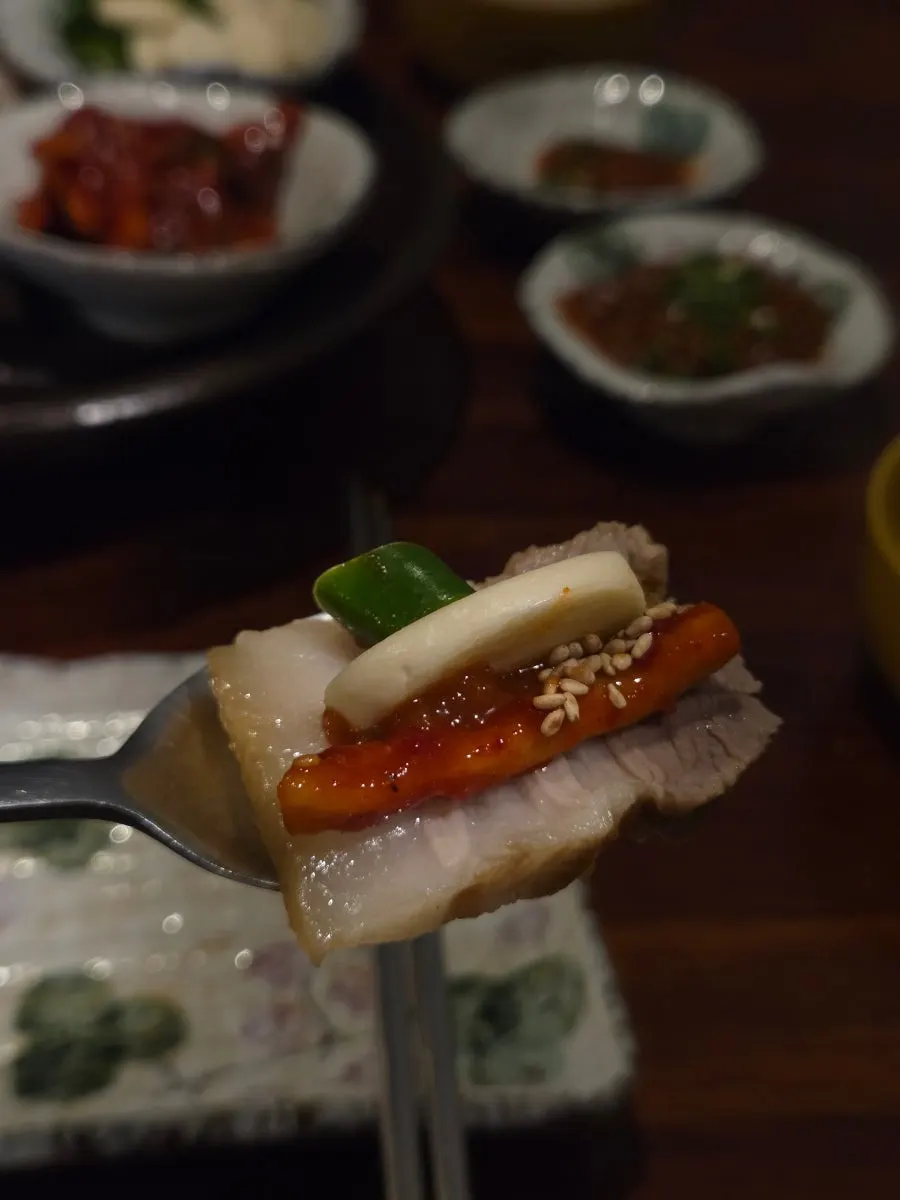 수육에 무말랭이와 마늘, 고추를 올린 한입