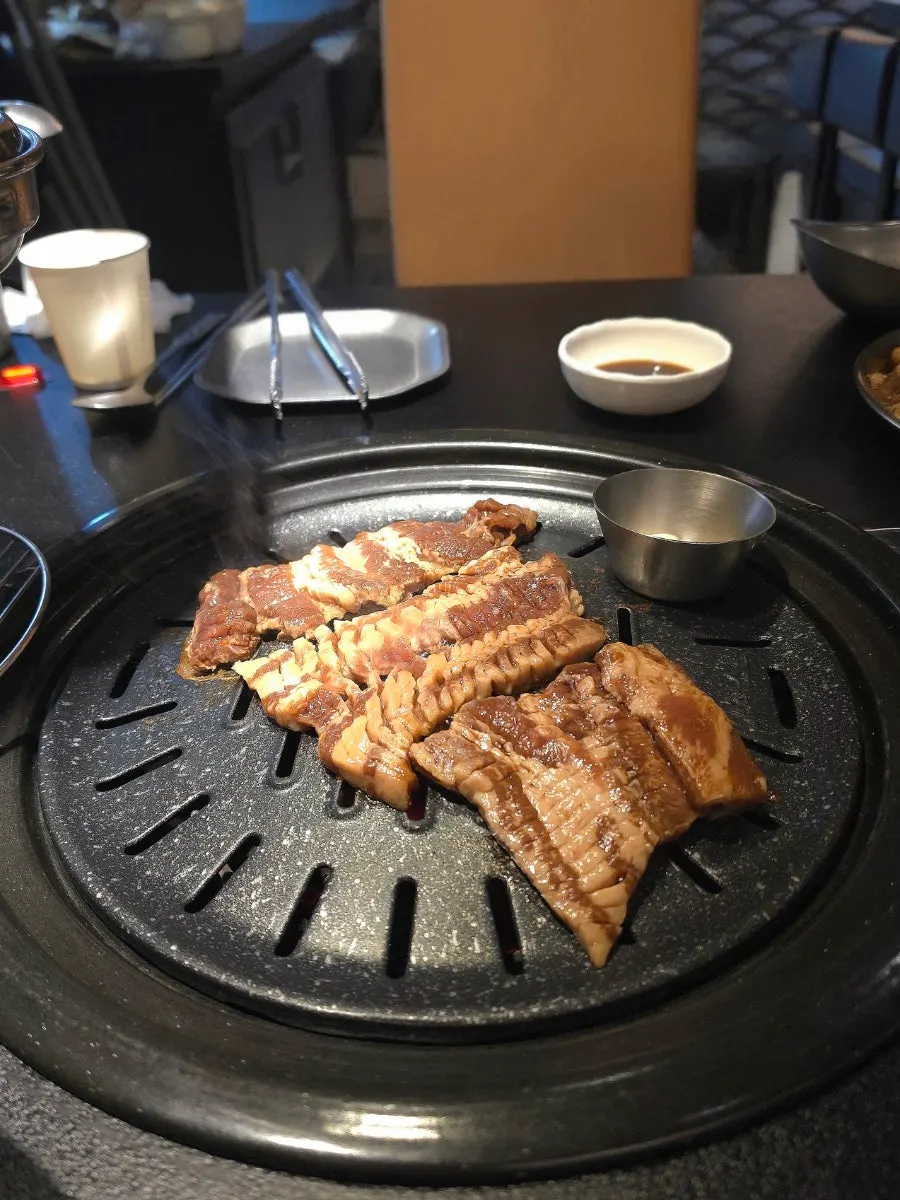 Marinated pork ribs beginning to grill over charcoal