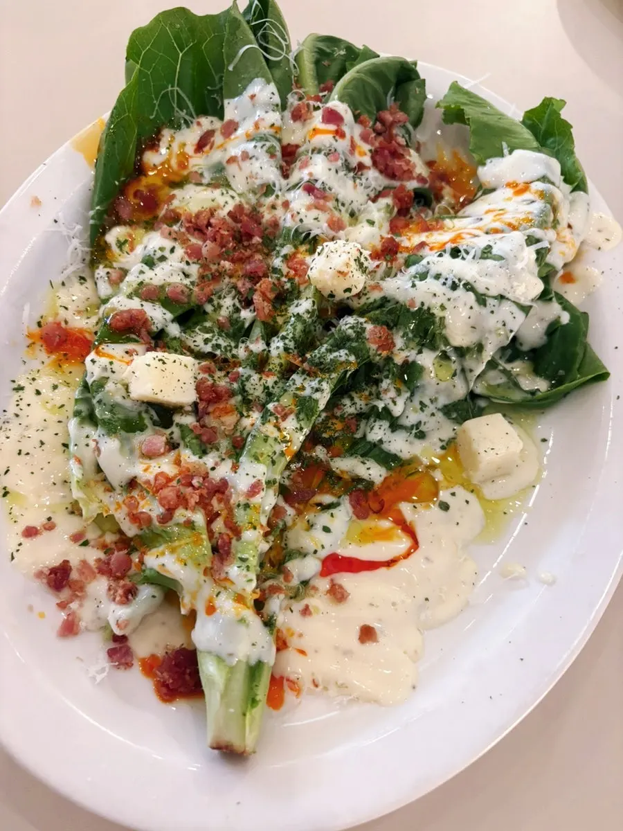Grilled romaine salad topped with cheese cubes