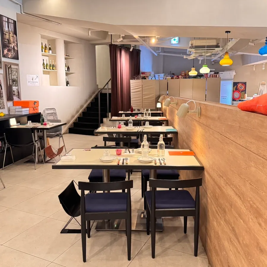 Farm-style dining hall interior with wood tones and plants