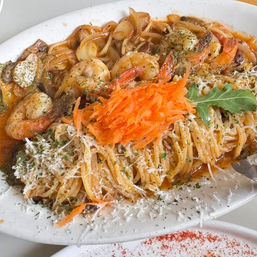 Close-up of oil pasta with carrot rapé