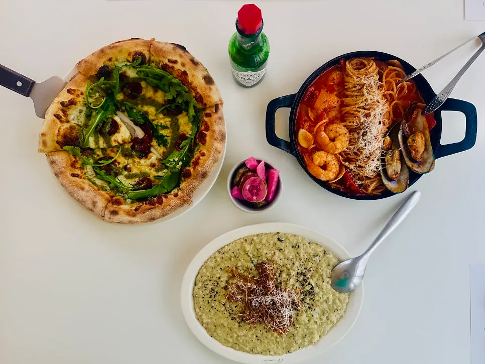 Table set with pizza, risotto, and pasta