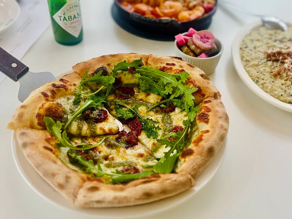 Pizza topped with arugula and prosciutto