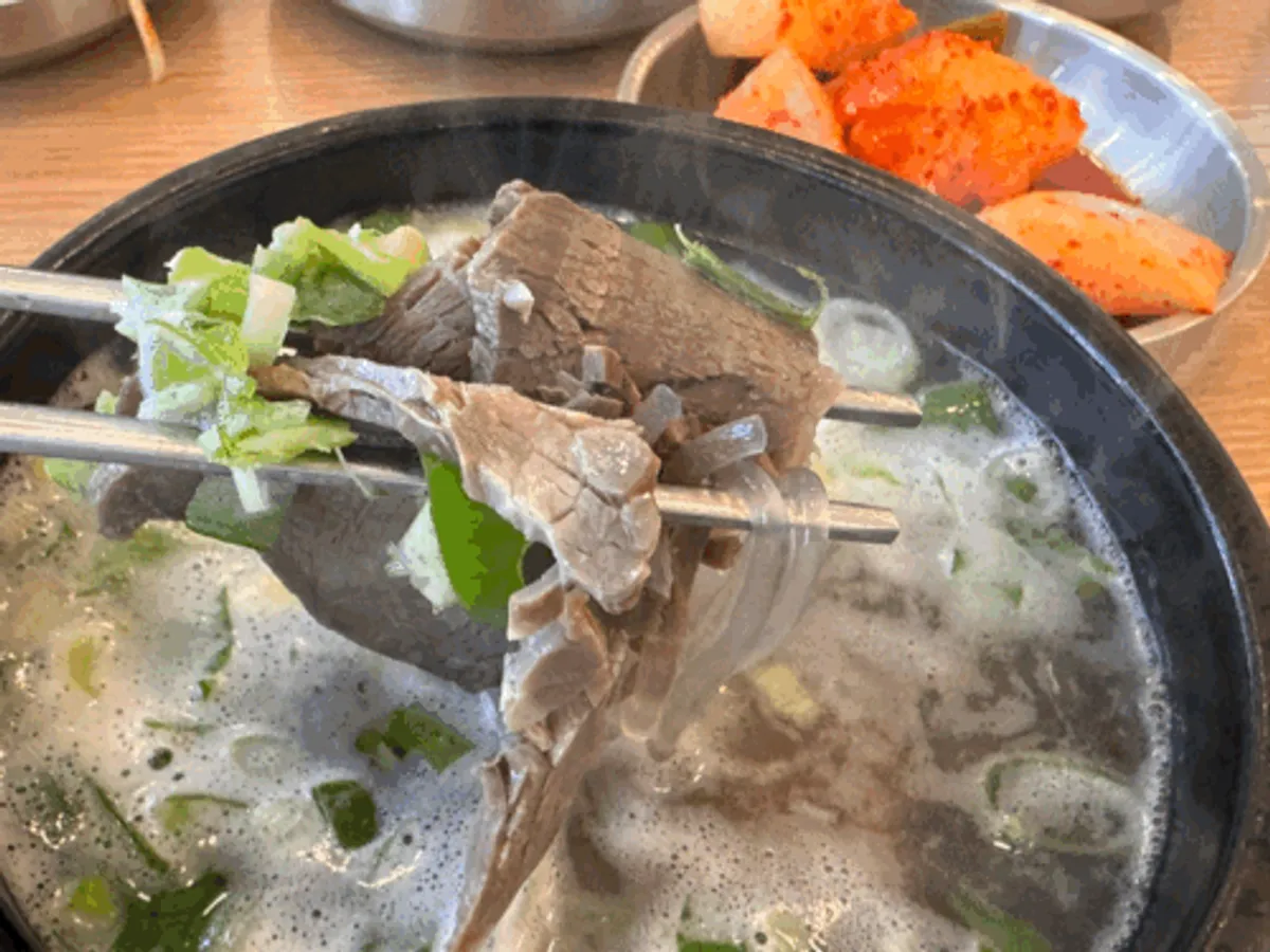 Clear gomtang broth topped with plenty of scallions
