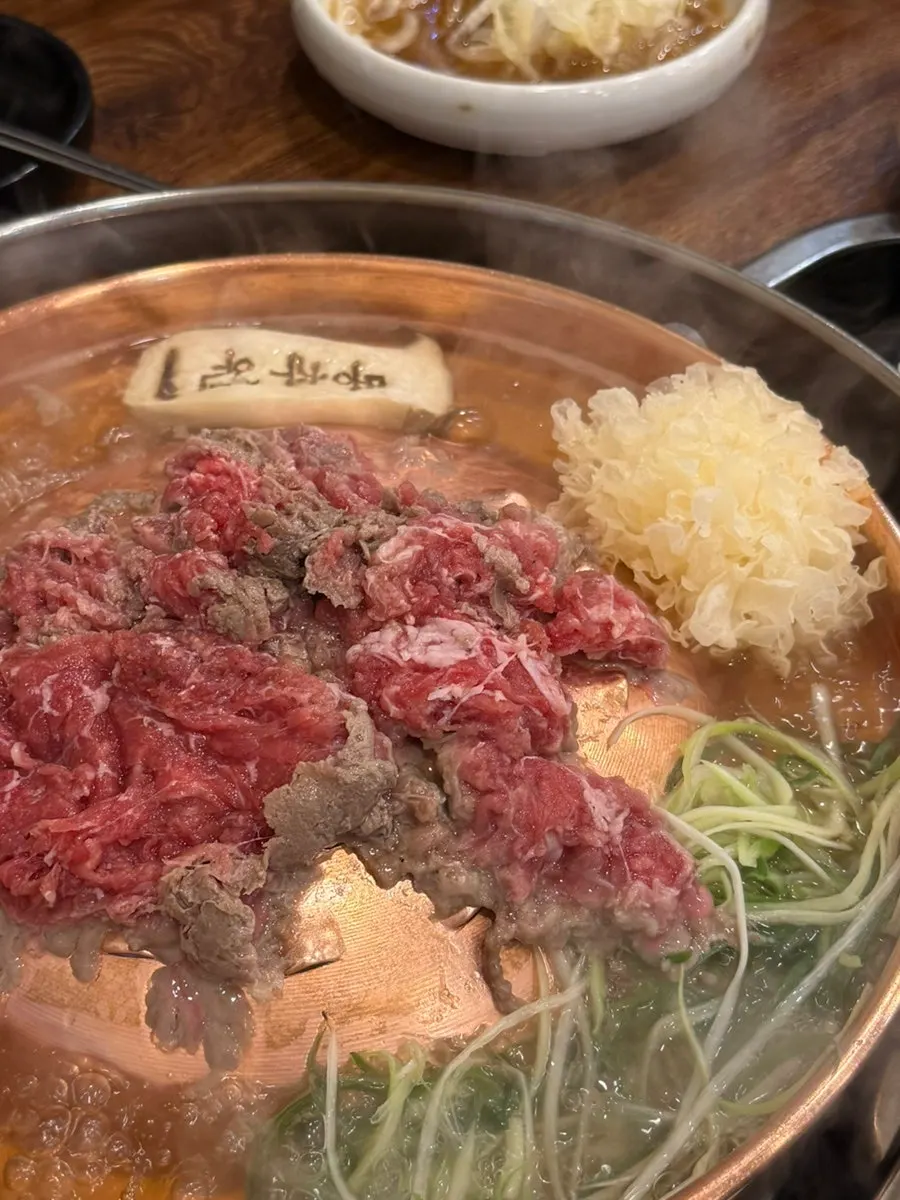 Pot of bulgogi set up with broth and noodles