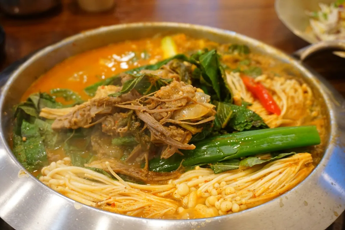 Korean beef lifted from the hot pot with chopsticks