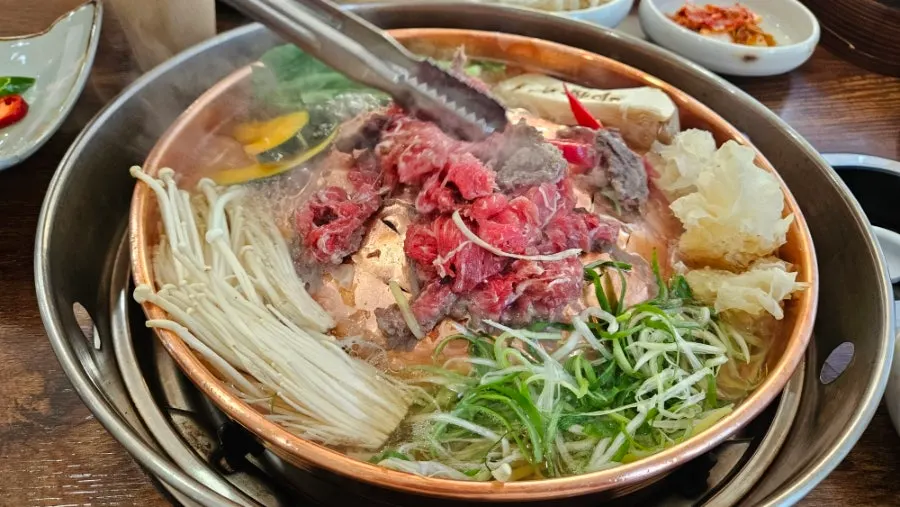Korean beef bulgogi picked up with tongs