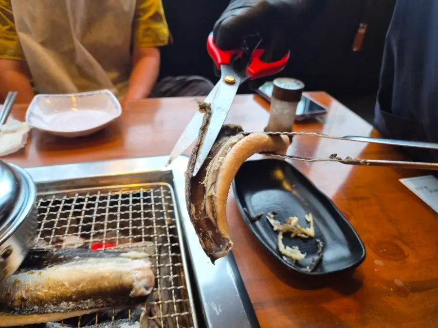 Staff hand trimming small side bones from the eel