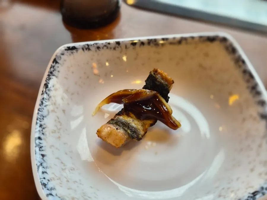First piece of eel topped with sauce and ginger