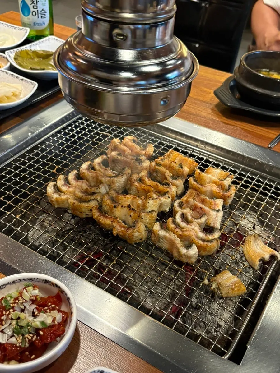 Staff member grilling eel into bite-sized pieces