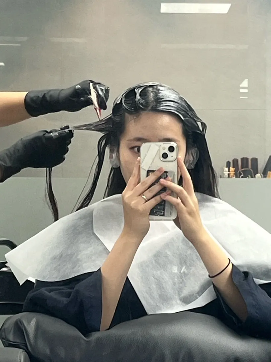 Hair with tone-down dye being applied