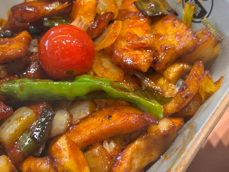 Close-up of the sauced, grilled pork jowl topping