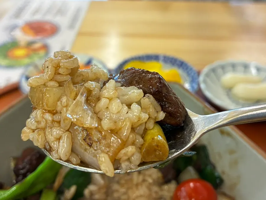 A spoonful of rice topped with cube steak