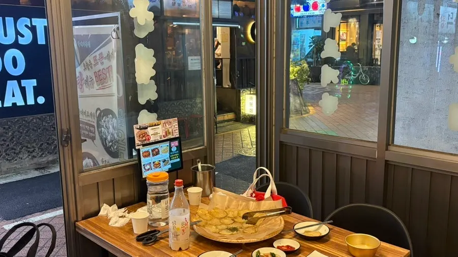 Table full of whole potato jeon and makgeolli